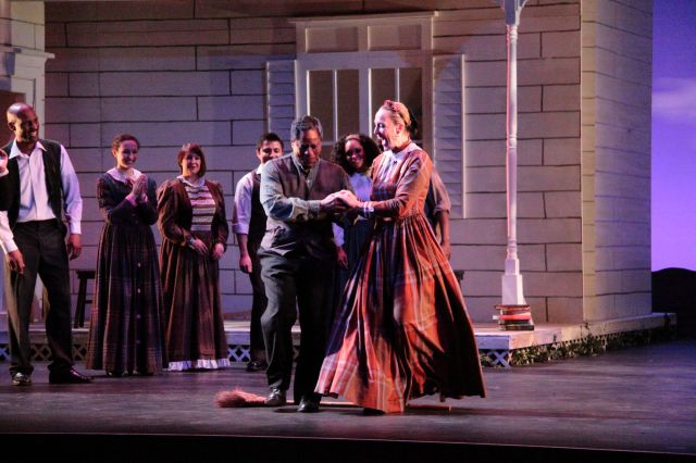 The joyful multiple weddings scene as one happy couple "jumps the broom" in a traditional practice of the era.